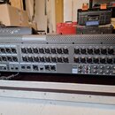 Šedý rackový stagebox s řadou vstupních konektorů. Na horní části je viditelné logo behringer a v pravé části jsou vstupy označené od IN 1 do IN 24.…