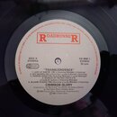 Fotografie zobrazuje bílý středový štítek vinylové desky s červeným logem ROADRUNNER. Štítek obsahuje text SIDE A, STEMRA, RR 9508 1 STEREO, 33 rpm a…