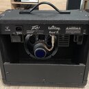 Zadní strana černého kytarového komba s rukojetí. Na zadním panelu jsou nápisy Peavey, ValveKing Royal 8 a text A PRODUCT OF PEAVEY ELECTRONICS CORP.…
