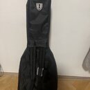 Černý softcase na kytaru z textilního materiálu. V horní části je bílé logo ve tvaru štítu s písmenem H. Pouzdro má v dolní části úchyt a kapsu s vid…