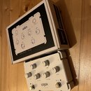 Bílý kytarový efekt pedál s nápisem KERNOM RIDGE a doprovodnou krabicí. Na pedálu jsou umístěny čtyři otočné knoflíky s popisky VOLUME, POST TONE, PR…