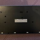 Zadní strana černého hudebního nástroje s bílým štítkem. Na štítku je uveden nápis KORG, MODEL: 4Mrt/baZ a AC ADAPTER DC9V. Jsou zde rovněž loga FCC,…