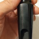 Černý munzpun z ebonitu s zlatým kroužkem v horní části. Povrch je hladký a bez viditelných poškrábaní. Na nástroji nejsou žádné čitelné značky ani n…