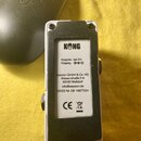 Zadní strana bílého kytarového efektu s černým spodním panelem. Na bílém štítku je logo KONG a nápisy: Adapter: 9 V, Polarity: (symbol polarity), ses…
