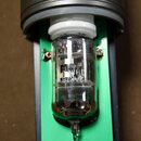 Kondenzátorový mikrofon s viditelnou elektronickou lampou v průhledném skle. Na horní části je nápis TAKSTAR a model CM-450, na lampě je text 12AX7B…