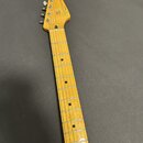 Hrabedlo elektrické kytary s hnedým dřevěným hmatníkem a hlavou. Na hlavě je vidět nápis Squier STRATOCASTER. Nástroj vykazuje běžné známky používání…