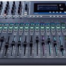 Černý kontrolní mixážní pult s mnoha posuvníky a tlačítky. V horní části je displej a nápisy Soundcraft a SIMPACT. Na ovládacím panelu jsou viditelní…