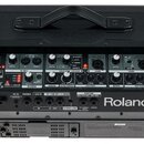 Zadní strana černého komba značky Roland. Na ovládacím panelu jsou viditelné nápisy CUBE Street EX a Roland, spolu s řadou regulačních knoflíků a pře…