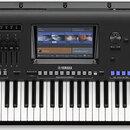 Černý digitální klavír s nápisy Genos a YAMAHA. Nástroj disponuje displejem, několika řadami tlačítek, posuvníkymi a standardní klaviatura. Povrch je…