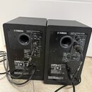 Dva černé aktivní reproduktory značky YAMAHA, model MODEL HHS. Na zadní straně jsou viditelné ovládací prvky pro LEVEL a ROOM CONTROL, vstupy INPUT 1…