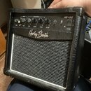 Černý kytarový kombo zesilovač s látkovou mřížkou reproduktoru v šedé barvě. Na ovládacím panelu jsou nápisy INPUT, CHANNEL SELECT, GAIN, BASS, MIDDL…