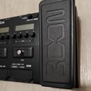 Černý kytarový pedál s výrazným vyvýšeným pedalboardem, na kterém je vylisované logo BOSON. Za pedálem je ovládací panel s dvěma displeji, několika o…