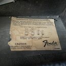 Fotografie zachycuje papírovou nálepku s informacemi o elektronkách v zesilovači. Na štítku je nápis FENDER MUSICAL INSTRUMENTS, FULLERTON, CA a logo…