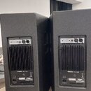 Dvě černé reproduktorové bedny s texturovaným povrchem. Na zadní straně každého reproduktoru je ovládací panel s konektory a nápisem RH SOUND HC-12P,…