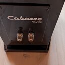Zadní strana černého audio zařízení s nápisem Cabasse FRANCE. Jsou zde vidět dva kovové konektory pro připojení kabelů. Povrch je hladký a černý, v r…
