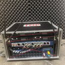 Hliníkový transportní kufr s nápisem TOP na víku, v němž jsou namontována čtyři rackové jednotky. Horní zařízení mají nápis ML1000/7, druhé zařízení…