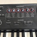 Detail ovládacího panelu černé klaviatury s nápisem KEYBOARD. V horní části je sekce SOUND MODIFY se šesti otočnými knoflíky obalenými červenými krou…