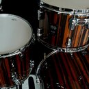 Sada bubnů s hnědým tmavě pruhovaným povrchem a chromovaným kováním. Na jednom z tomů je viditelný nápis 15" a AQ2 s logem značky Sonore. Na kování v…