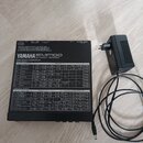 Černý efektový procesor YAMAHA EMP100 MULTI-EFFECT PROCESSOR s bílým tabulkovým přehledem parametrů na horní straně. Zařízení má v zadní části konekt…