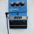 Modrý kytarový efekt s třemi ovládacími knoflíky popsanými jako DELAY, MIX a REPEAT. Na přední straně je nápis FX 90 Delay a červená kontrolka. Spodn…