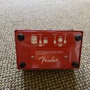 Zadní strana červeného kytarového pedálu s logem Fender. Na povrchu jsou bílé schéma zapojení s nápisy AMP 1, GUITAR, ABY1 a AMP 2. Dole je text: For…