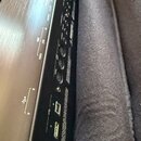 Detail zadní strany černého elektronického hudebního zařízení s různými konektory. Jsou zde viditelné nápisy MIDI IN, OUT a THRU u příslušných portů,…