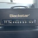 Černý kytarový zesilovač s nápisem Blackstar. Na předním panelu jsou ovládací prvky rozdělené do sekcí REVERB, EQUALISATION, OVERDRIVE a CLEAN, s ozn…