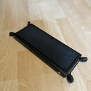 Černý obdélníkový pedalboard s protiskluzovou gumovou povrchovou vrstvou. Na rohach jsou umístěny čtyři nastavitelné nožičky. Povrch a rám vykazují m…