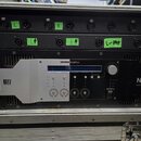 Černý rackový zesilovač značky NEXO s nápisem powered by YAMAHA a označením DIGITAL NXAMP4x4. Zařízení je umístěno v transportním kufru a má stříbrný…