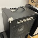 Černý basový kombo zesilovač s kovovými rohy a rukojetí. Na přední mřížce je bílo-černý nápis Hartke HD50. Horní panel obsahuje několik ovládacích kn…