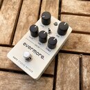 Bílý kytarový efekt s nápisem evermore. a UAFX STUDIO REVERB. Na horní straně jsou čtyři černé otočné knoflíky s popisky MOD, MIX, BASS a TREBLE, dva…