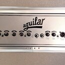 Stříbrný basový zesilovač v rackovém šasi s černým předním panelem. Uprostřed je výrazné logo aguilar a vlevo nápis DB 751. Panel obsahuje ovládací k…