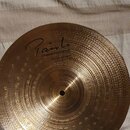 Zlatavý kovový činel s viditelným broušením a hloubením povrchu. Na povrchu je černý nápis „Paiste INNOVATIONS HEAVY HI-HAT 14"“. Činely vykazují mír…