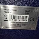Kovová identifikační štítka připevněná na modrý texturovaný povrch. Na štítku je uveden nápis MODEL: SV112, 70W RMS, LEAD 1x12", 16Ω a CE. Dále je zd…