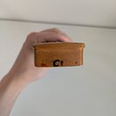 Detail dřevěné části hudebního nástroje v hnědé barvě. Na povrchu je vidět černý nápis C1 a malá červená skvrna. Povrch vykazuje drobné odpáleniny a…
