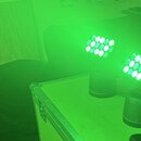 Dvě černé LED světla s pohyblou hlavou umístěná na transportním kufru. Obě jednotky svítí zeleným světlem z panelů s více LED diodami. Na přístrojích…