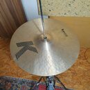 Kovový činel v zlatavé barvě s viditelným kovaným povrchem, umístěný na stojanu. Na povrchu je černé logo ve tvaru velkého písmene K a nápis MEINL MA…