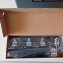 V kartonové krabici je v plastovém obalu umístěn černý stupňový pedalboard. Na horní straně jsou viditelné nápisy Blackstar, CH1, CH2 a různé funkční…