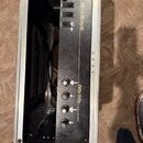 Černý kytarový zesilovač v hliníkovém transportním kufru. Na přední straně je zlatý nápis Mesa BOOGIE a model Fifty/Fifty s doplňkem STEREO TUBE POWE…