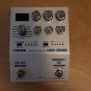 Stříbrný efektový pedál s nápisy BOSS DIGITAL DELAY DD-200. Zařízení má šest otočných knoflíků, několik přepínačů a čtyři kontrolní LED diody. V doln…
