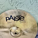 Zlatý mosazný činel s koncentrickým žebrováním. Na povrchu je černý nápis Paiste, pod ním označení 101 BRASS a text 13" HI-HAT BOTTOM. Povrch je čist…