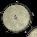 Fotografie zachycuje horní pohled na buben s béžovou membránou a černým obručem. Uprostřed membrány je logo s nápisem TOCA PERCUSSION a textem COMMUT…