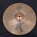 Bronzový činel s kovaným povrchem. Na horní části je nápis Custom Special Dry HIHAT BOTTOM 14"/35cm a ve spodní části velké písmeno K. Na pravém okra…