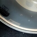 Detail vnitřní strany obruče bubnu s nápisem SONOR. Vedle loga je štítek s textem Geprüft a dále nálepka s označením SQ2 10237100. Povrch je hladký a…