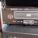 Černý rackový CD/MP3 přehrávač s nápisem OMNITRONIC XDP-1400 SINGLE CD/MP3-PLAYER. Na přední straně je tlačítko POWER, slot pro kompaktní disky s náp…