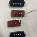 Dvě humbuckerové snímače s červenobroudy tělem a dvěmi černými plastovými kryty. Na tělech snímačů jsou viditelné bílé nápisy 027036. Snímače jsou pr…