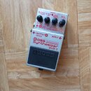 Kytarový efekt pedál značky BOSS, model Bass Synthesizer SYB-3. Zařízení má stříbrné kovové tělo s černým gumovým spínacím pedálem. Na horní straně j…