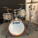 Celá bicí souprava s přirozeným dřevem a kovovým kováním. Na basovém bubnu je čitelné logo TAMA. Souprava obsahuje snare, tom a sadu činelů na chromo…