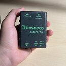 Černý kovový box s nápisy v zelené barvě. Uprostřed je logo a název značky bespeco a pod ním model DBX-10. V horní části jsou popisky link output a b…