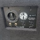 Detail zadní strany černého reproduktoru s nápisem FULL RANGE. Je zde vidět regulační knoflík LEVEL CONTROL, logo SWR a štítek s textem CR- 294090, S…